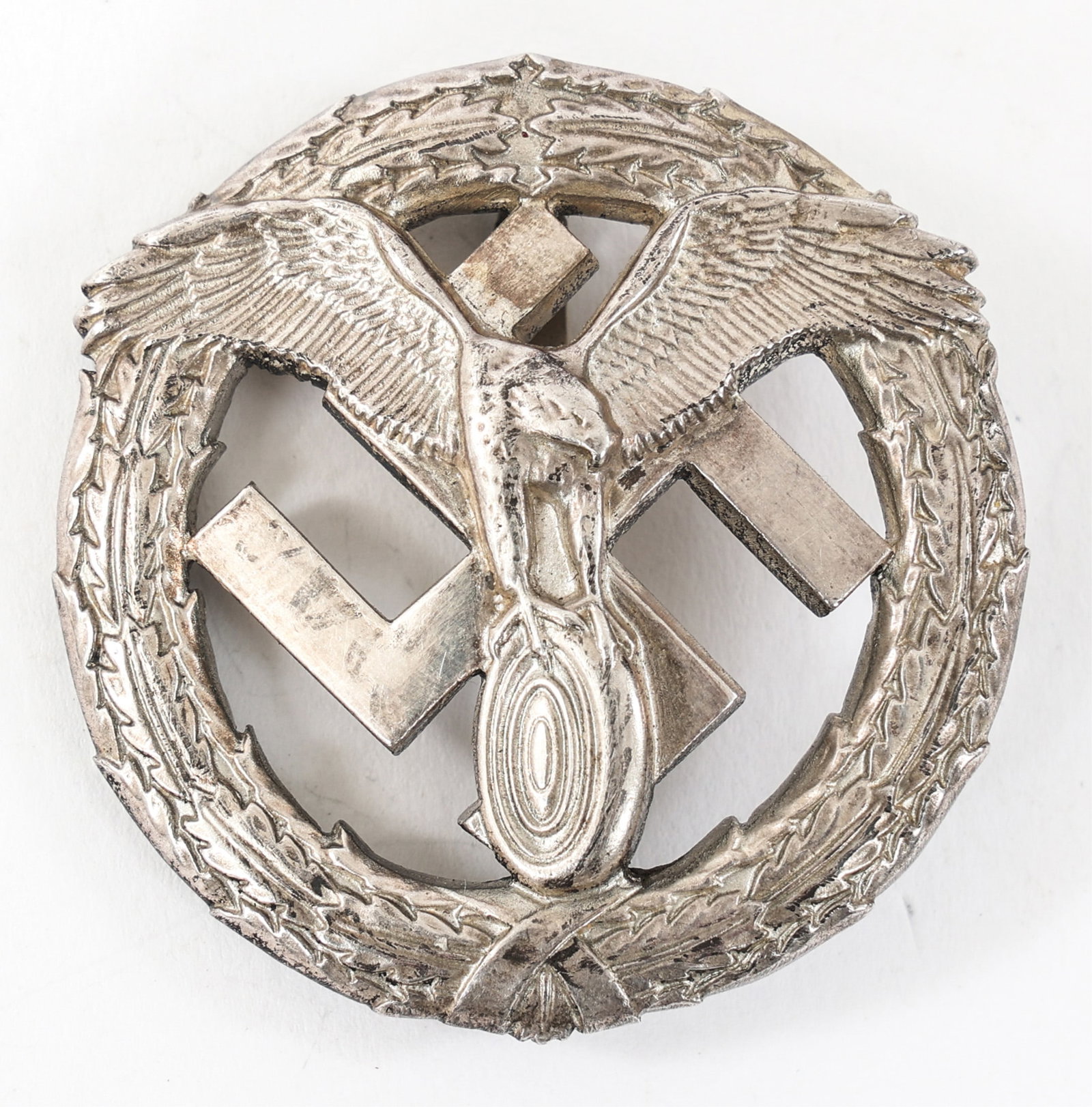WWII GERMAN NSKK MOTORSPORTS BADGE IN SILVER: WWII GERMAN NSKK MOTORSPORTS BADGE IN SILVER WWII German NSKK Motorsports Badge in Silver. Pin back. Maker marked "LN 1700" and stamped "800" on the reverse.