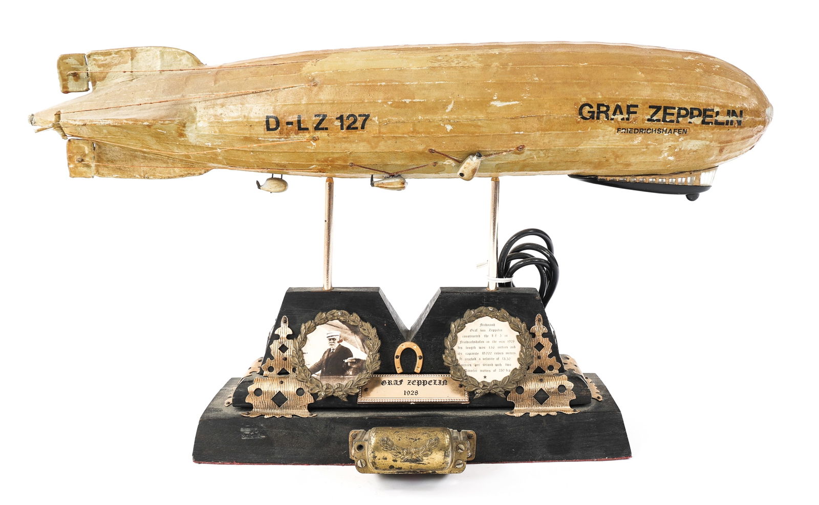 GERMAN LZ-127 GRAF ZEPPELIN DISPLAY MODEL: GERMAN LZ-127 GRAF ZEPPELIN DISPLAY MODEL German 1928 LZ-127 "Graf Zeppelin" Aircraft Display Model. Complete with Airship model and illuminated base. No light bulbs present. | Size: 23" x 16"