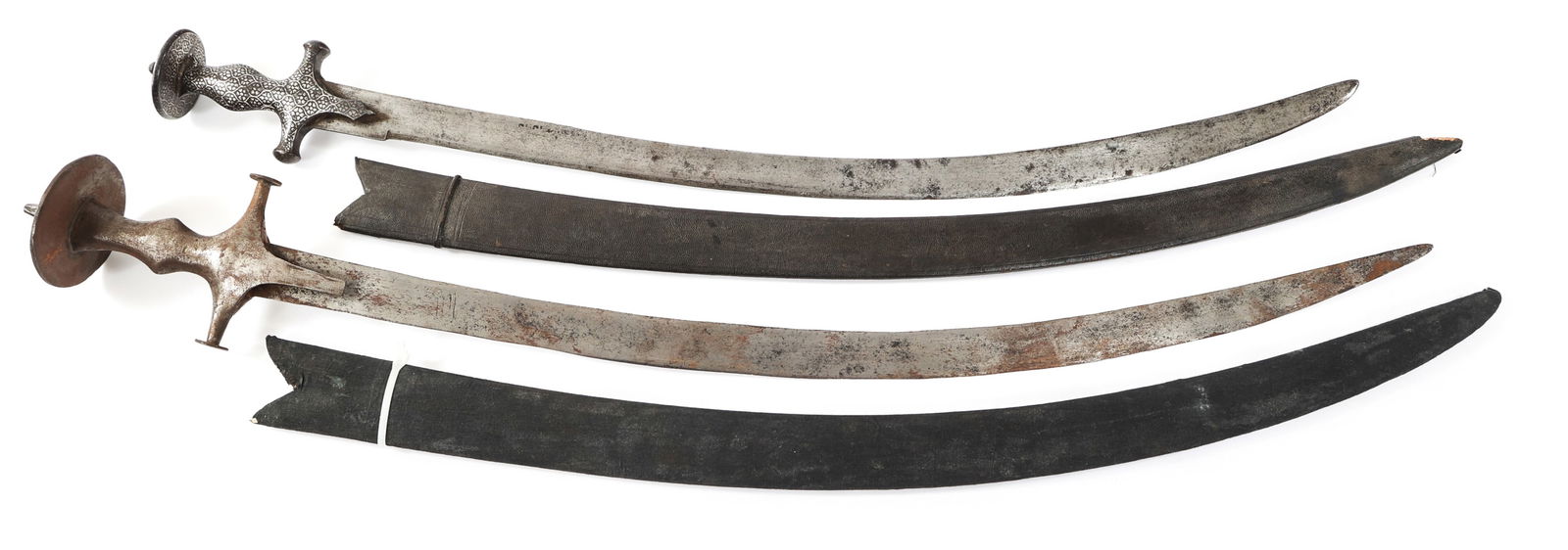 19th C. INDIAN TULWAR SWORDS: 19th C. INDIAN TULWAR SWORDS 19th C. Indian Tulwar Swords. Single edged, curved blades. Steel hilts. One hilt is decorated with floral patterns. Leather covered wood scabbards. No visible marks or sta