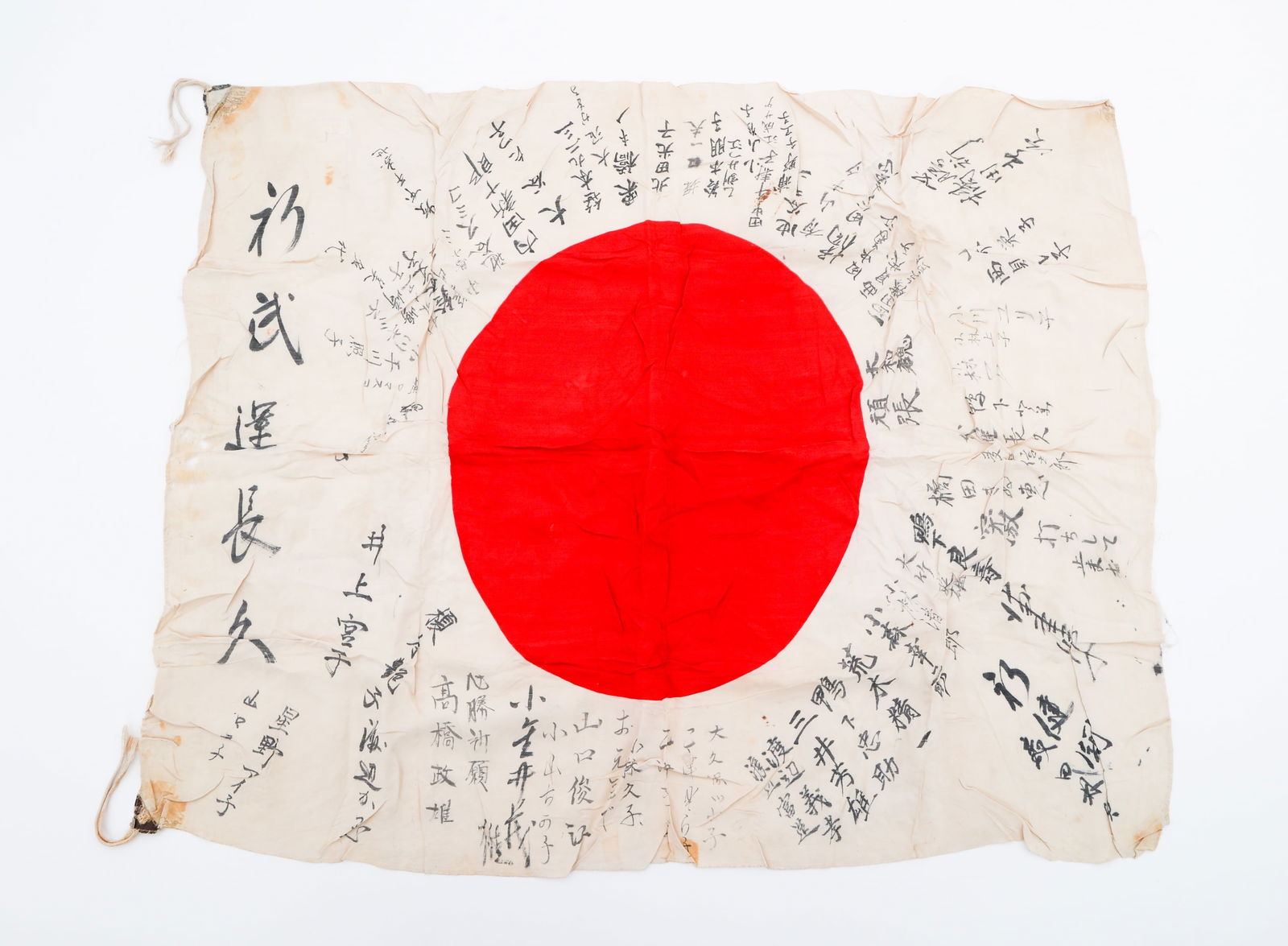 WWII JAPANESE YOSEGAKI HINOMARU FLAG: WWII JAPANESE YOSEGAKI HINOMARU FLAG WWII Imperial Japanese Yosegaki Hinomaru Flag. Linen one-piece construction with printed emblem. Handwritten kanji inscriptions throughout. Size: 27" x 34"