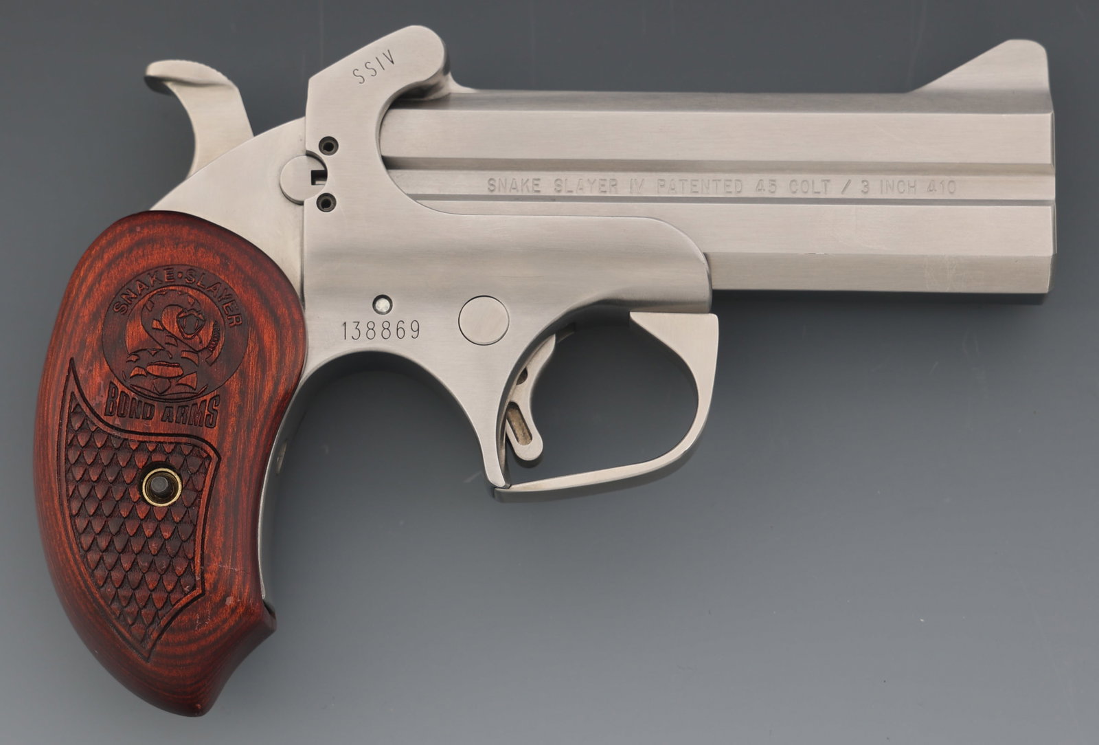 BOND ARMS SNAKE SLAYER IV 45LC / 410 GA DERRINGER: BOND ARMS SNAKE SLAYER IV 45LC / 410 GA DERRINGER Bond Arms Snake Slayer IV .410 gauge / .45 Colt caliber derringer pistol. Fixed sights. Checkered wood grips. Caliber / Gauge: 45 LC / 410 Barrel Leng