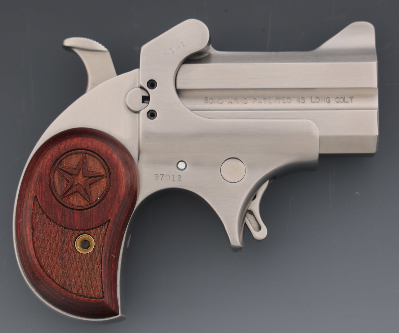 BOND ARMS MINI .45 LONG COLT CALIBER DERRINGER: BOND ARMS MINI .45 LONG COLT CALIBER DERRINGER Bond Arms Model Mini .45 Long Colt caliber Derringer pistol. Fixed sights. Checkered wood grips. Caliber / Gauge: 45 LC Barrel Length: 2.5" Serial Number