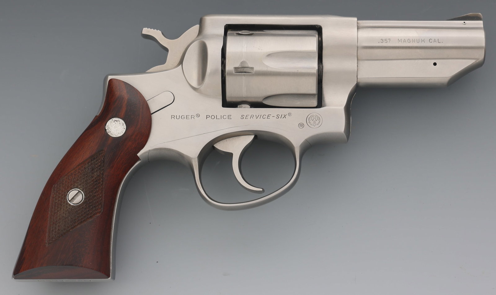 RUGER MODEL POLICE SERVICE-SIX 357 MAGNUM REVOLVER: RUGER MODEL POLICE SERVICE-SIX 357 MAGNUM REVOLVER Ruger Model Police Service-Six .357 Magnum caliber DA revolver. Six-shot fluted cylinder. Checkered wood grips with Ruger medallion. Fixed sights. Fa