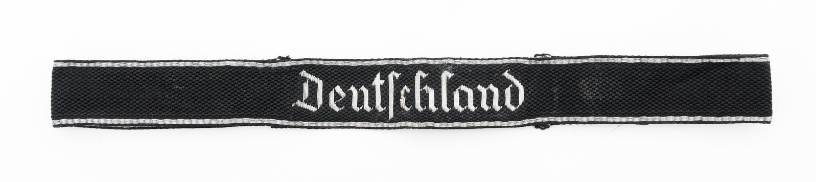 WWII GERMAN SS DEUTSCHLAND OFFICER CUFF TITLE: WWII GERMAN SS DEUTSCHLAND OFFICER CUFF TITLE WWII German SS Standarte Deutschland Officer Cuff Title. Cotton/rayon blend construction with silver threaded bullion stitching. RZM 11/37 tag present.