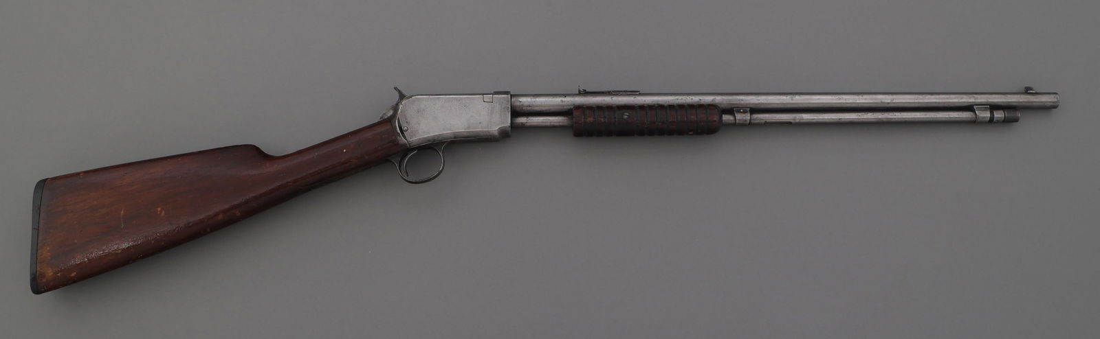 WINCHESTER MODEL 1906 .22 S-L-LR CALIBER RIFLE: WINCHESTER MODEL 1906 .22 S-L-LR CALIBER RIFLE Winchester Model 1906 .22 S-L-LR caliber slide action takedown rifle. Blade front sight. Adjustable rear sight. Wood stock. Checkered Winchester butt pla