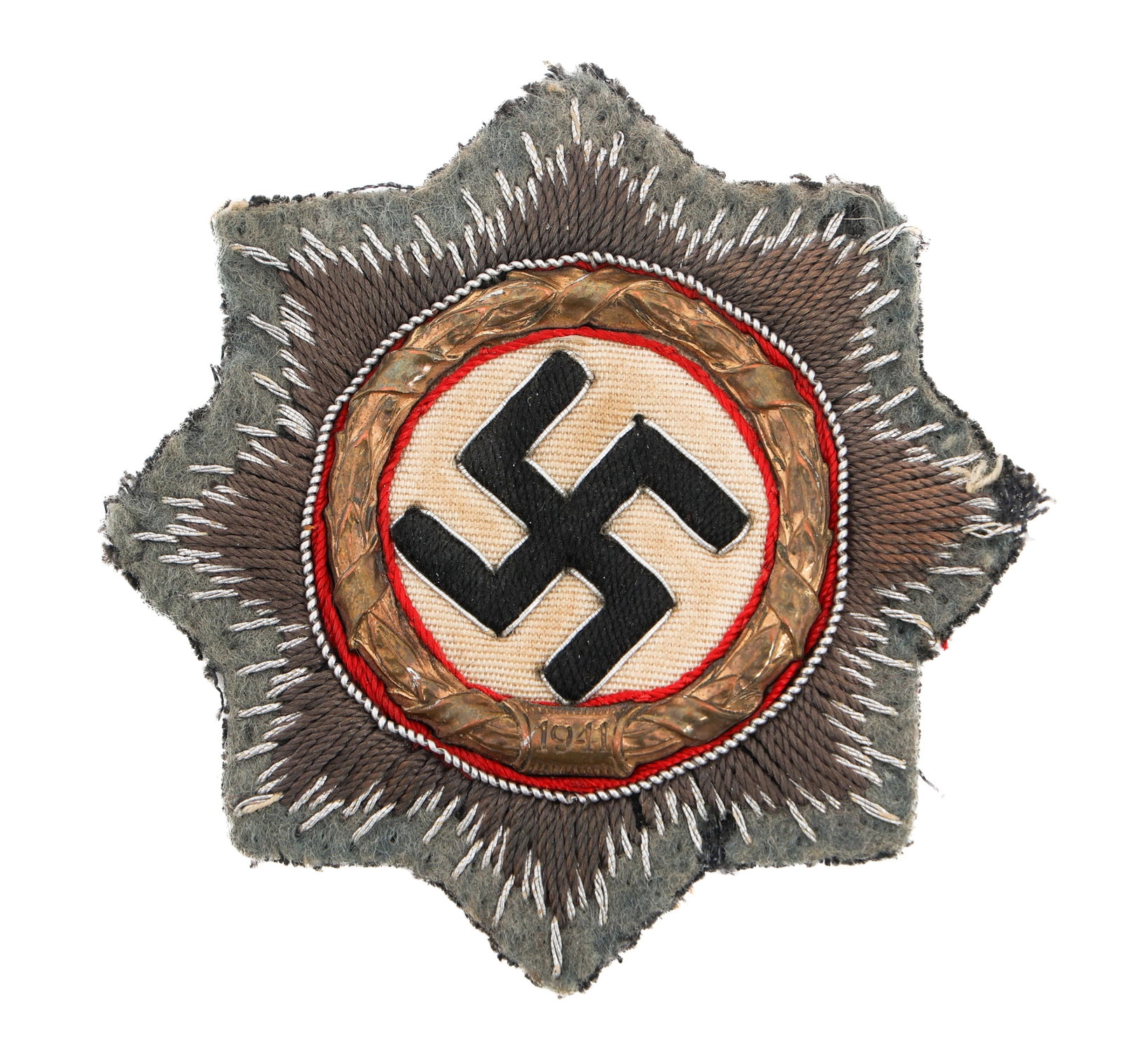 WWII GERMAN CROSS IN GOLD CLOTH BULLION EMBROIDERY: WWII GERMAN CROSS IN GOLD CLOTH BULLION EMBROIDERY WWII German Cross In Gold. Silver Bullion Cloth Embroidery. Paper backing with manufacturer tag by A. Westmann, Dresden. Size: 72.5 mm Provenance: Li