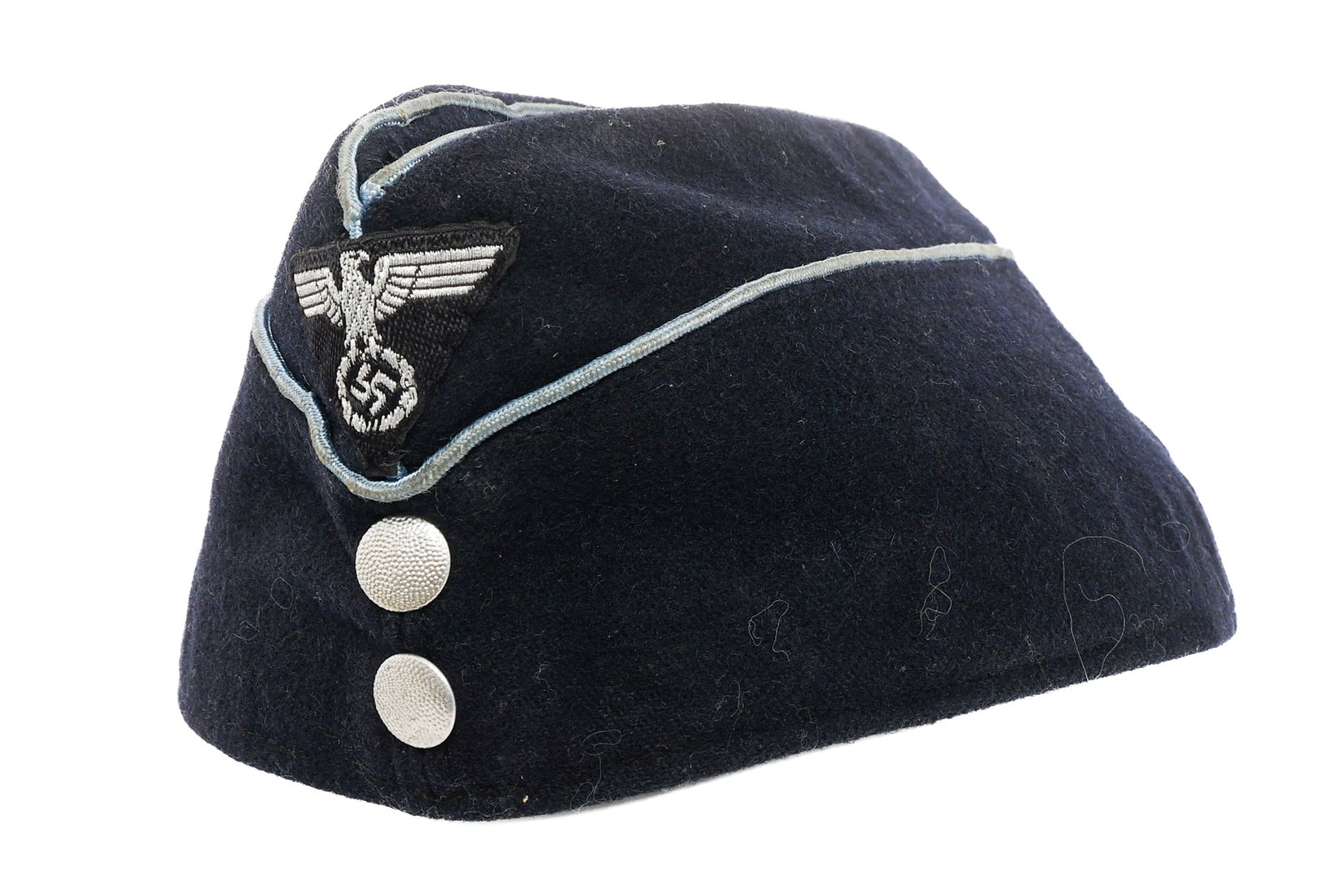 WWII GERMAN DAF GARRISON CAP: WWII GERMAN DAF GARRISON CAP WWII German DAF Garrison Cap. Dark blue wool construction with light blue piping and pebbled steel buttons. Black German eagle cloth cap badge. Leather sweatband. RZM tag 