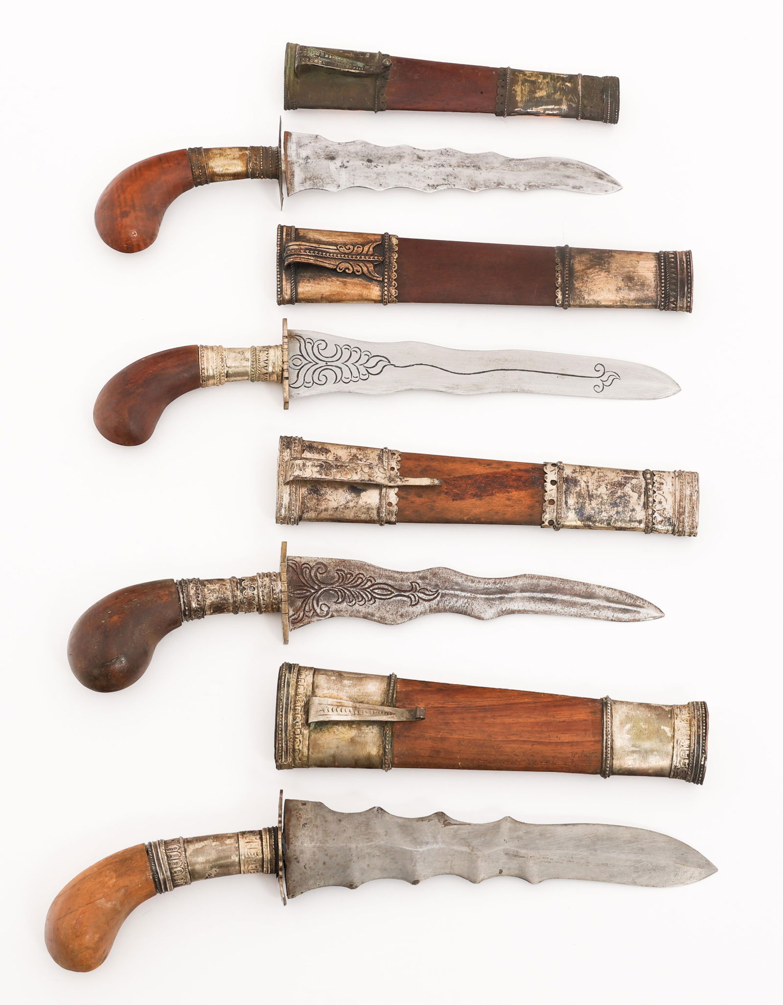 SOUTHEAST ASIAN PUNAL DE KRIS KNIVES: SOUTHEAST ASIAN PUNAL DE KRIS KNIVES Four Southeast Asian Puñal de Kris Knives. Double edged, wavy blades. Two have etched designs on both sides. No visible maker marks. Brass and alloy hilts with wo