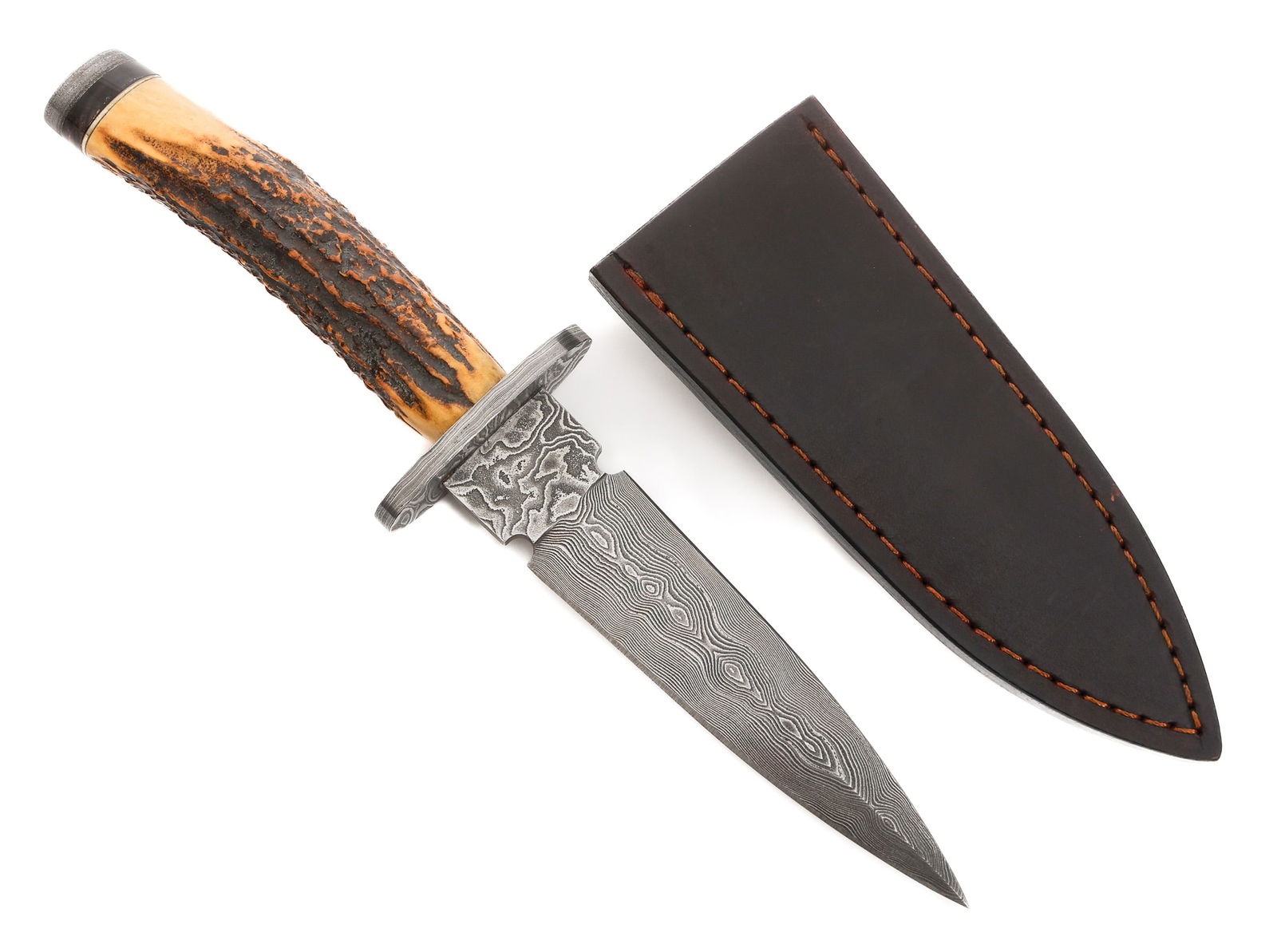 STAG HORN DAMASCUS DAGGER by STEK KNIVES: STAG HORN DAMASCUS DAGGER by STEK KNIVES Stag Horn Damascus Dagger. Double edged, Damascus blade. Maker marked by Stek Knives on the ricasso. Damascus steel crossguard and pommel with bone handle. Lea