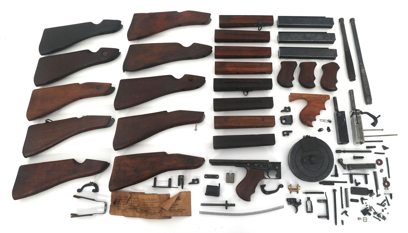 THOMPSON SUBMACHINE GUN PARTS: THOMPSON SUBMACHINE GUN PARTS Thompson Submachine Gun parts. Barrels. Stocks. Three unmarked stick magazines. One Russian drum magazine modified to fit re-welded trigger housing assembly. Bolts. Small