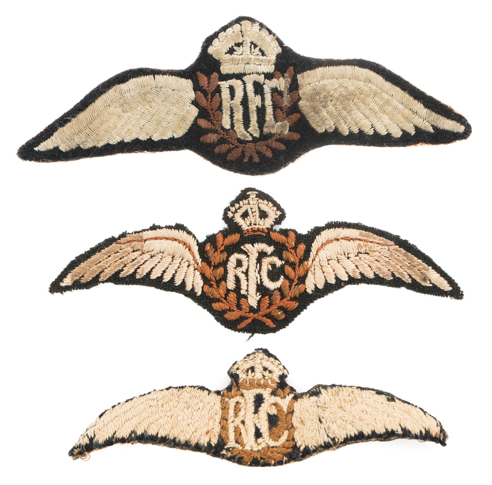 WWI BRITISH RFC EMBROIDERED PILOT WING BADGES: WWI BRITISH RFC EMBROIDERED PILOT WING BADGES Three WWI British RFC Pilot Wing Badges. Embroidered cotton. One with wire pinback. Size: 3 3/4" to 4 1/2"