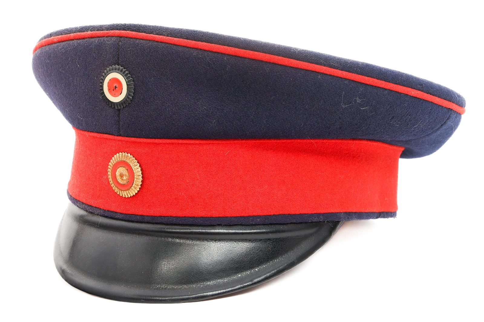 IMPERIAL GERMAN BADEN INFANTRY SCHIRMMUTZE CAP: IMPERIAL GERMAN BADEN INFANTRY SCHIRMMUTZE CAP Imperial German Baden Infantry EM/NCO Schirmmutze Cap. Dark-blue wool with red piping and cap band. Baden and National painted cockades. Leather sweatban