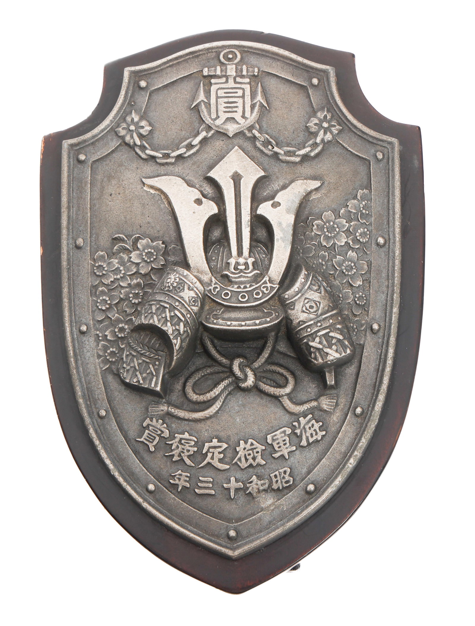 WWII IMPERIAL JAPANESE NAVY AWARD PLAQUE: WWII IMPERIAL JAPANESE NAVY AWARD PLAQUE WWII Imperial Japanese Navy Award Plaque. Wooden plaque with stand, and steel emblem featuring a Kabuto and floral design with Kanji. Dated 1938. Size: 4" x 6"