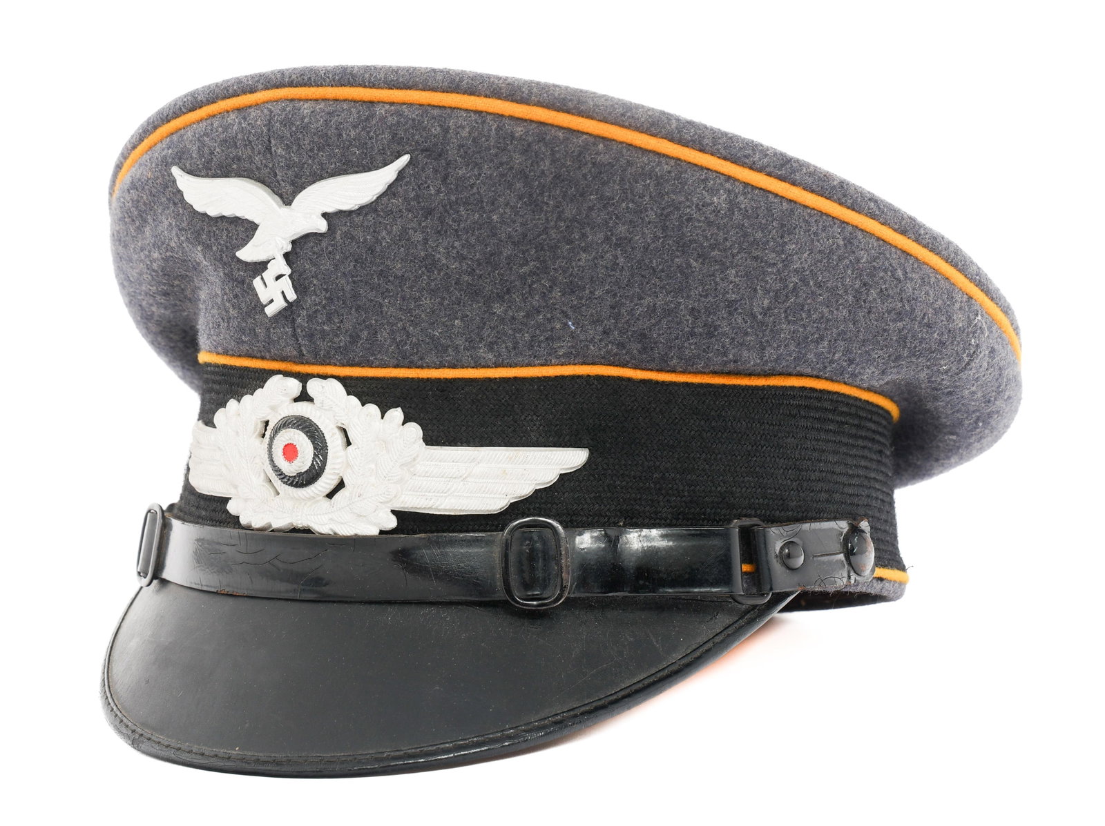 WWII GERMAN LUFTWAFFE FLIGHT NCO VISOR CAP: WWII GERMAN LUFTWAFFE FLIGHT NCO VISOR CAP WWII German Luftwaffe Flight NCO Visor Cap. Blue-grey wool with yellow waffenfarbe. Aluminum Luftwaffe eagle and wreathed cockade cap badges. Black leather c