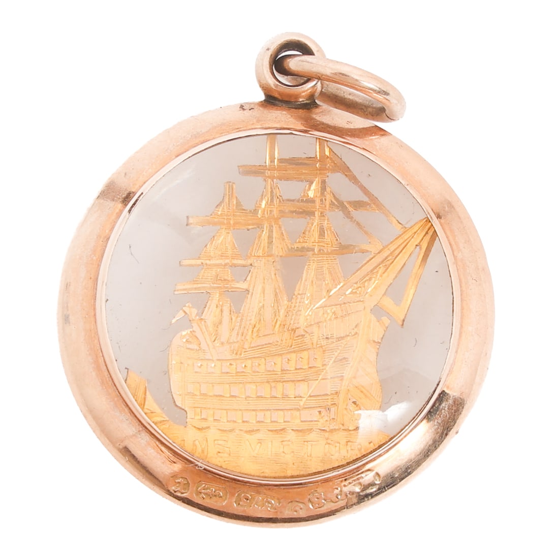 BRITISH NAVY 9K GOLD HMS VICTORY PENDANT: BRITISH NAVY 9K GOLD HMS VICTORY PENDANT Early 20th C. British Navy 9k Gold HMS Victory Pendant. Double sided glass and gold design with hand-chased HMS Victory. British Hallmarked on bottom of