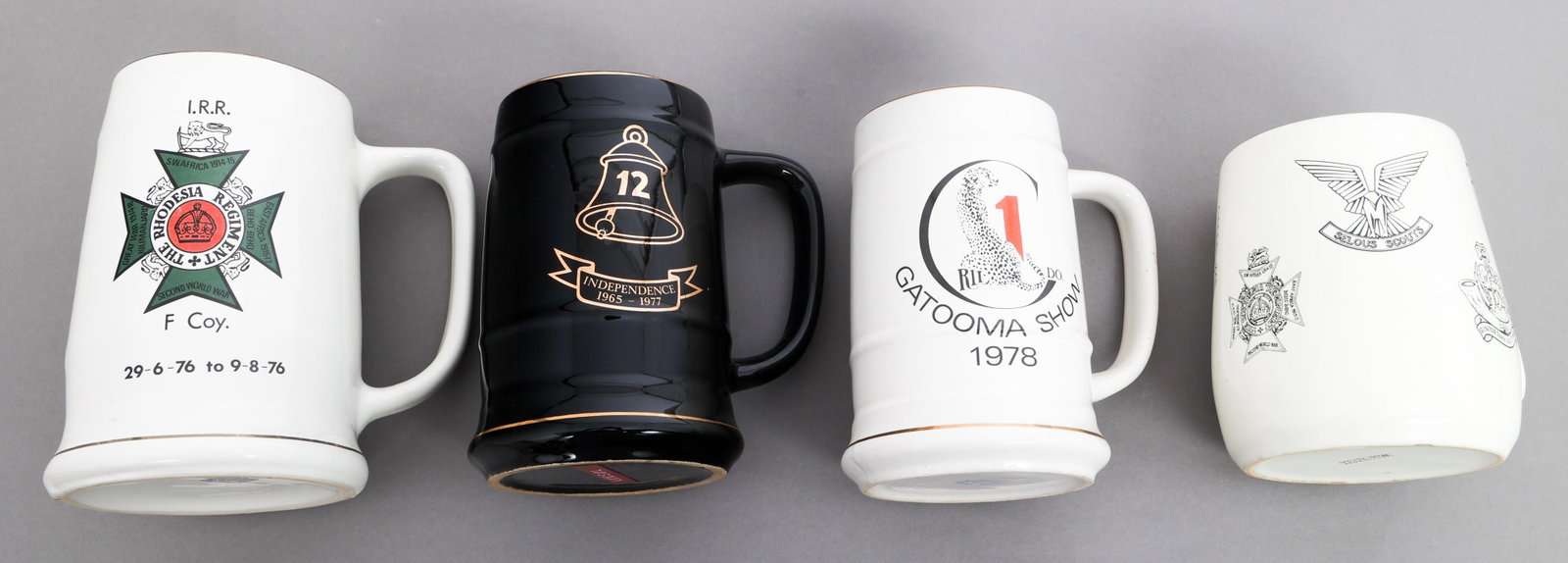 BUSH WAR RHODESIAN REGIMENTAL BEER STEINS: BUSH WAR RHODESIAN REGIMENTAL BEER STEINS Bush War Rhodesian Regimental Beer Steins. (1) 12th Anniversary of Independence Stein. Dated 1965 to 1977. (1) Named The Rhodesian Regiment Stein. Named to F.