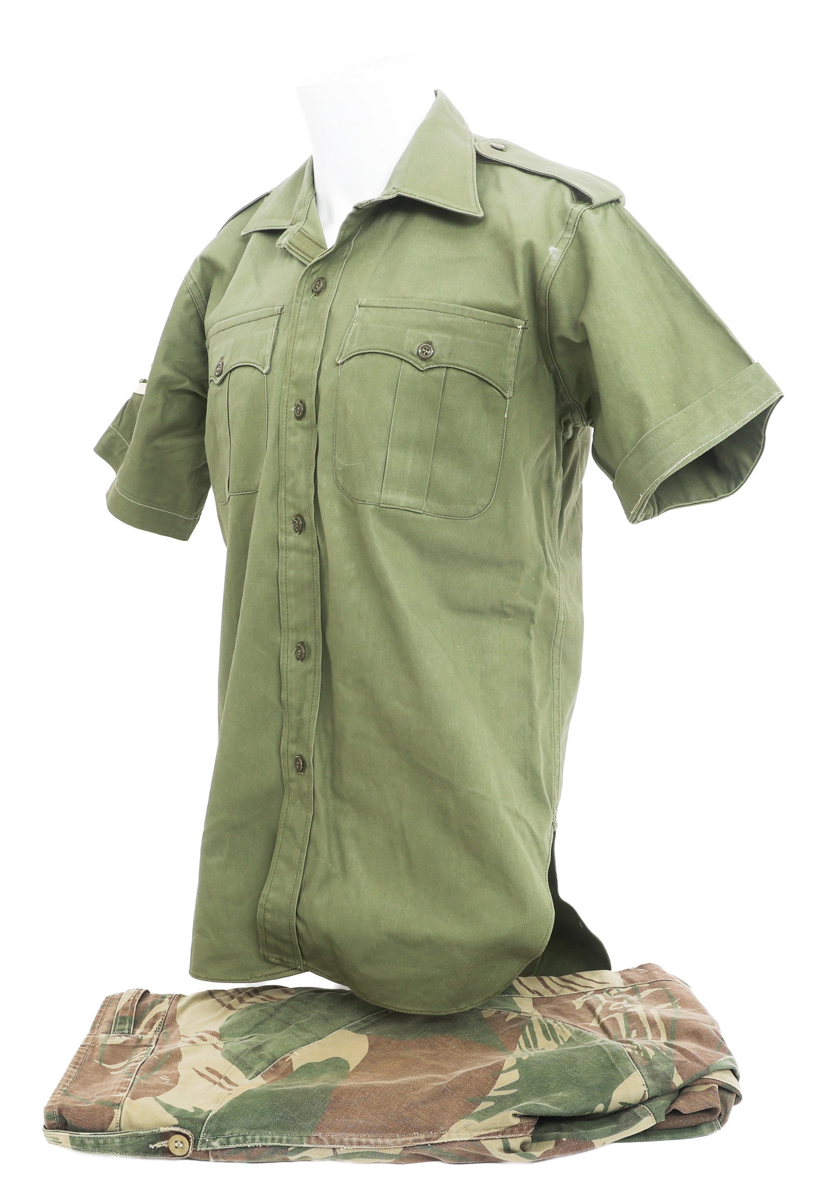 BUSH WAR RHODESIAN NAMED GREEN & CAMO UNIFORM: BUSH WAR RHODESIAN NAMED GREEN & CAMO UNIFORM Bush War Rhodesian Brushstroke Camouflage Named Uniform. (1) Olive Dress Shirt. 100% Cotton with two pockets, green buttons, Sergeant insignia, and tag