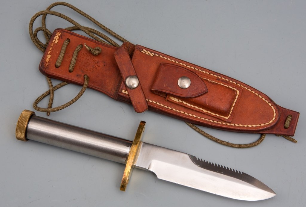RANDALL MODEL 18 ATTACK SURVIVAL KNIFE: RANDALL MODEL 18 ATTACK SURVIVAL KNIFE 5.75 inch blade10.6 inches overall. 11 inch leather sheath. Compass in brass pommel. Extremely good condition with minimal sheath marks. Est. 500 - 600