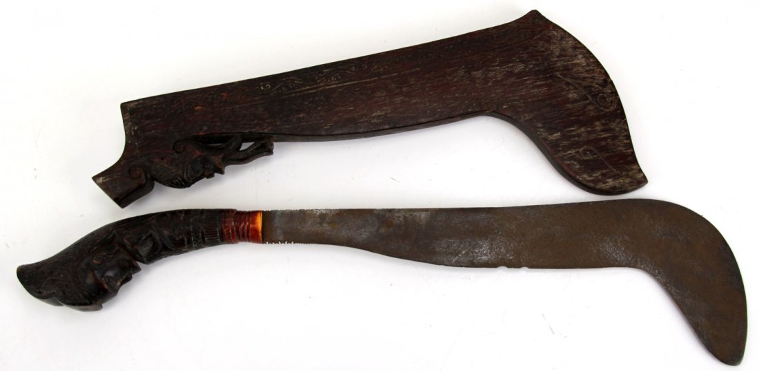 PHILIPPINE CANE KNIFE IN WOODEN SCABBARD: PHILIPPINE CANE KNIFE IN WOODEN SCABBARD Early 20th Century Philippine knife in carved dark wood scabbard. Handle is carved in the figure of a ceremonial head, with bone ferrule, and 12 inch blade wit