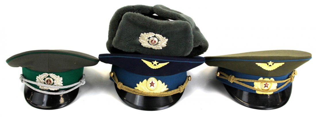 FOUR COLD WAR SOVIET & EAST GERMAN HATS: FOUR COLD WAR SOVIET & EAST GERMAN HATS Four Cold War era hats. Two Soviet Air Force hats, East German officer's cap, and East German wool winter cap. Country: Russia