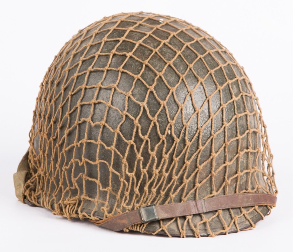 WWII US M-1 HELMET WITH LINER AND FISHNET COVER: WWII US M-1 HELMET WITH LINER AND FISHNET COVER Era / Conflict: WWII Country: US Provenance: From the collection of Robert D. Mitchell, who served in the U.S. Army from September 1976 thru February 20