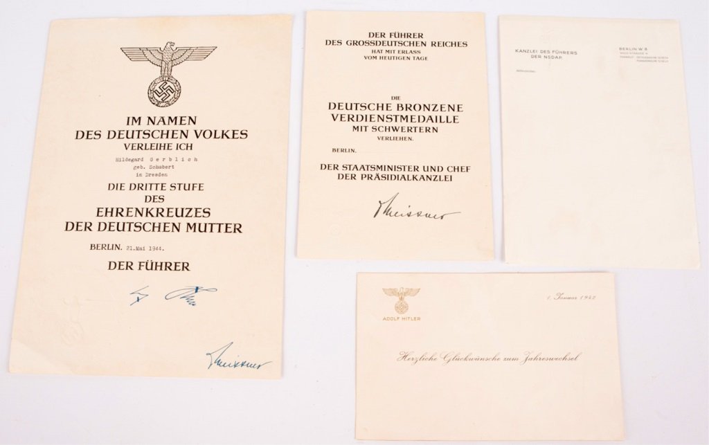 LOT OF WWII GERMAN DOCUMENTS & AWARDS: LOT OF WWII GERMAN DOCUMENTS & AWARDS 2 awards, NSDAP stationery, and an Adolf Hitler New Years card dated 1942