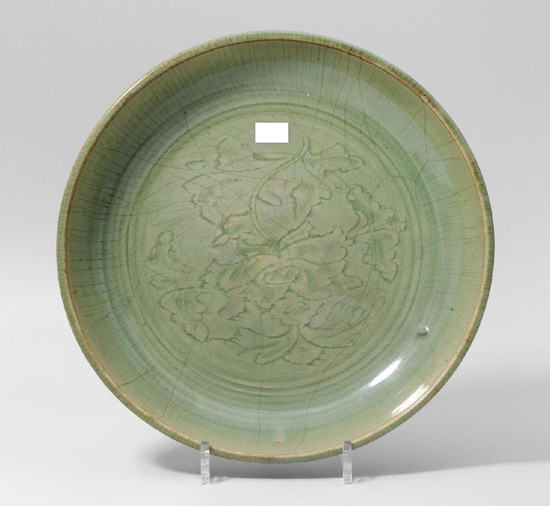 Platte China, wohl Ming-Zeit. Longquan. Celadon,: Platte China, wohl Ming-Zeit. Longquan. Celadon, craqueliert. Stilisierter Päoniendekor im Spiegel. D32 cm.