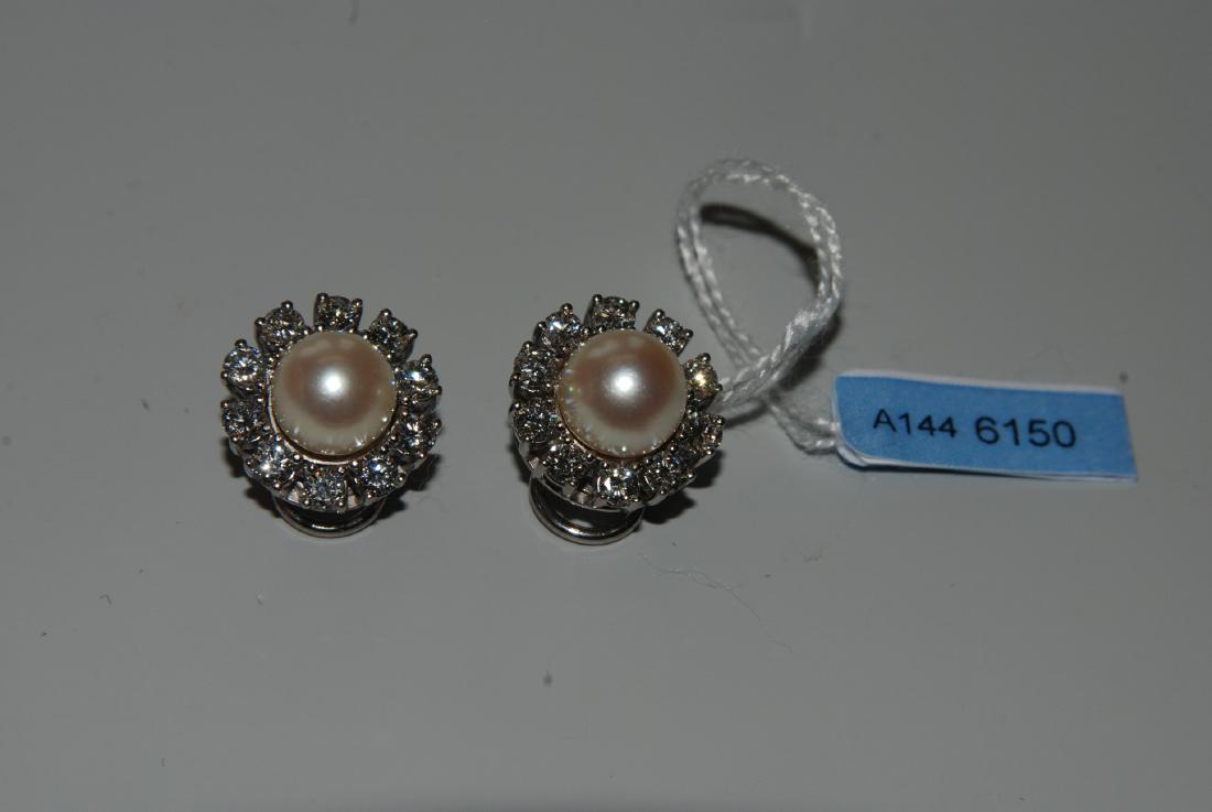 Perlen-Brillant-Ohrclips Bucherer. 2 Akoya-Kulturperlen: Perlen-Brillant-Ohrclips Bucherer. 2 Akoya-Kulturperlen Ø 8,5 mm und 20 Brillanten zus. ca. 1.68 ct. Ø 1,5 cm, 10,5 g.