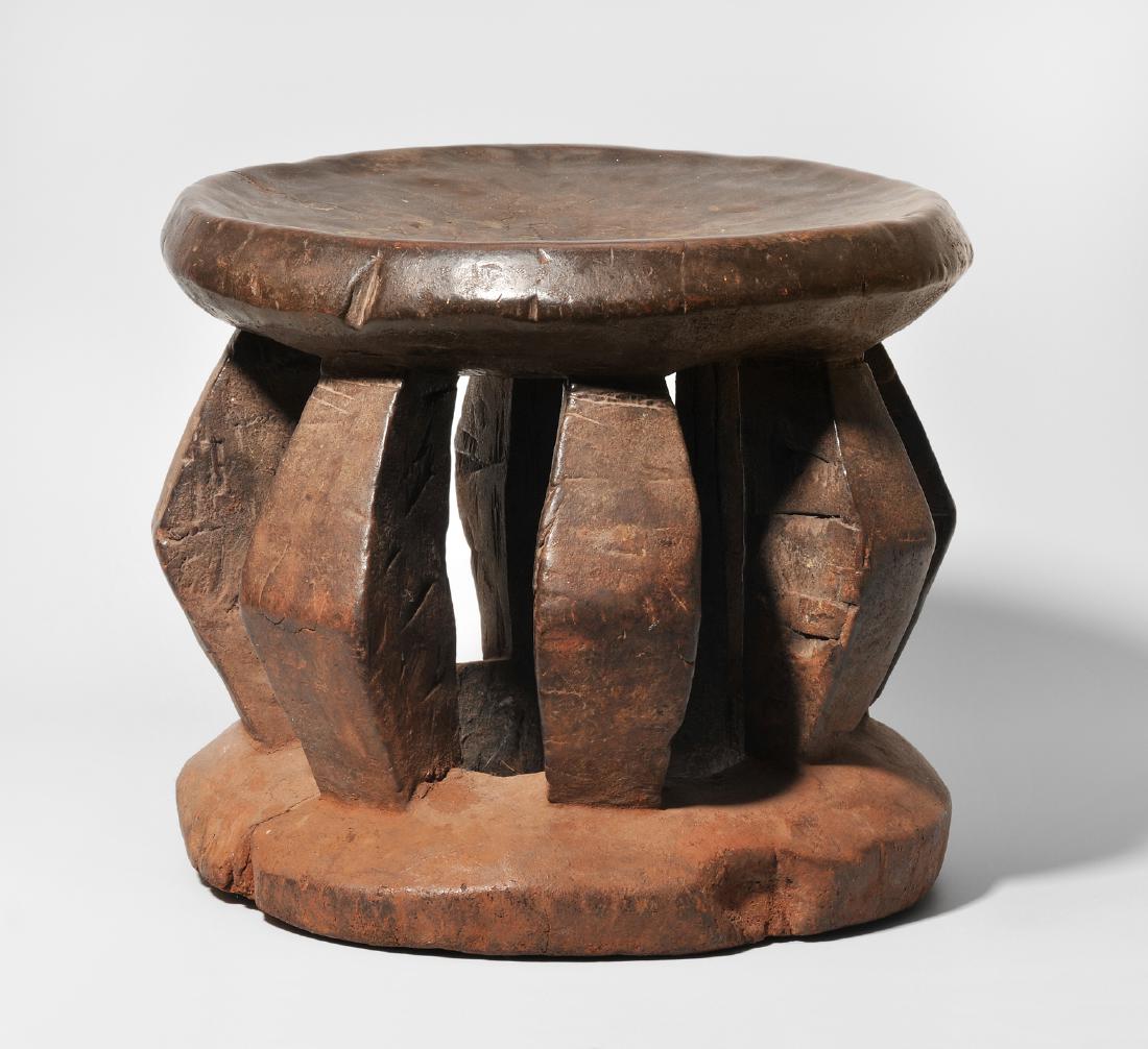 Hocker Kameruner Grasland. Hartholz. Runde Sitzfläche: Hocker Kameruner Grasland. Hartholz. Runde Sitzfläche auf acht abgewinkelten Stützen über Standring. H 29,5, D 34,5 cm. - Risse. Gebrauchspatina.