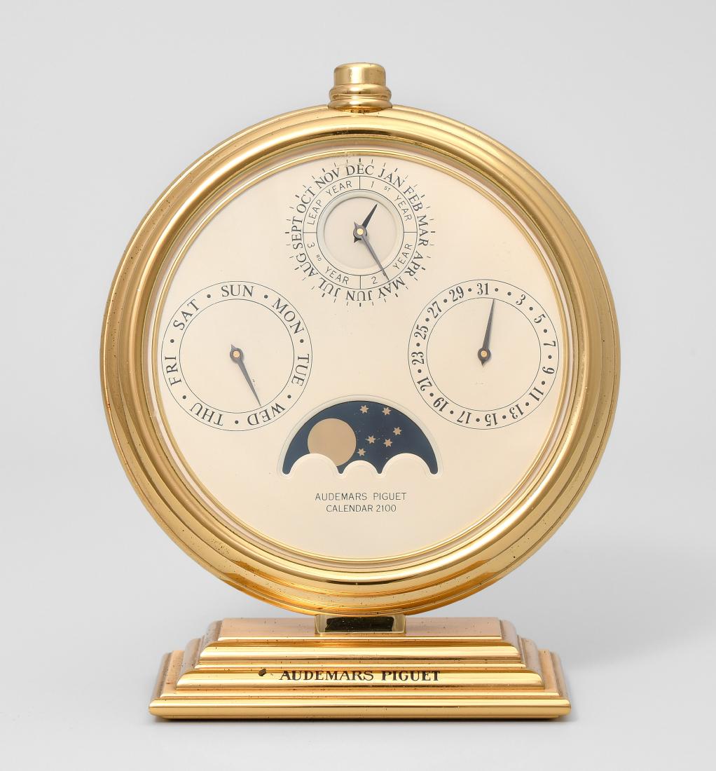 Calendar 2100, Audemars Piguet Schweiz, 20.Jh.: Calendar 2100, Audemars Piguet Schweiz, 20.Jh. Vergoldetes Messinggehäuse auf vergoldetem, signierten Messingfuss. Weisses Anzeigeblatt mit Monat und Jahr bei 12 Uhr, Tag bei 3 Uhr, Wochentag bei 9 U