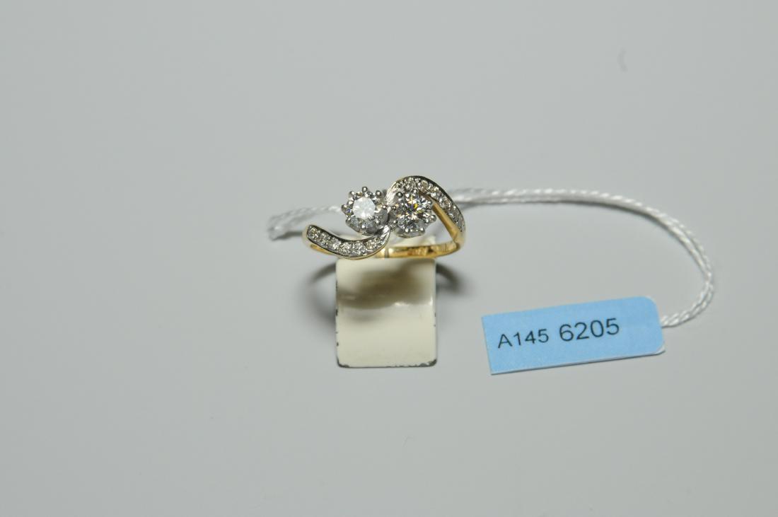 Brillant-Ring Um 1920. 750 Gelb- und Weissgold.: Brillant-Ring Um 1920. 750 Gelb- und Weissgold. Croisé-Modell mit 2 Brillanten, zus. ca. 0.70 ct, H-P1. Ringschultern mit 12 kl. Brillanten, ca. 0.16 ct. Gr. 53, 3,5 g.