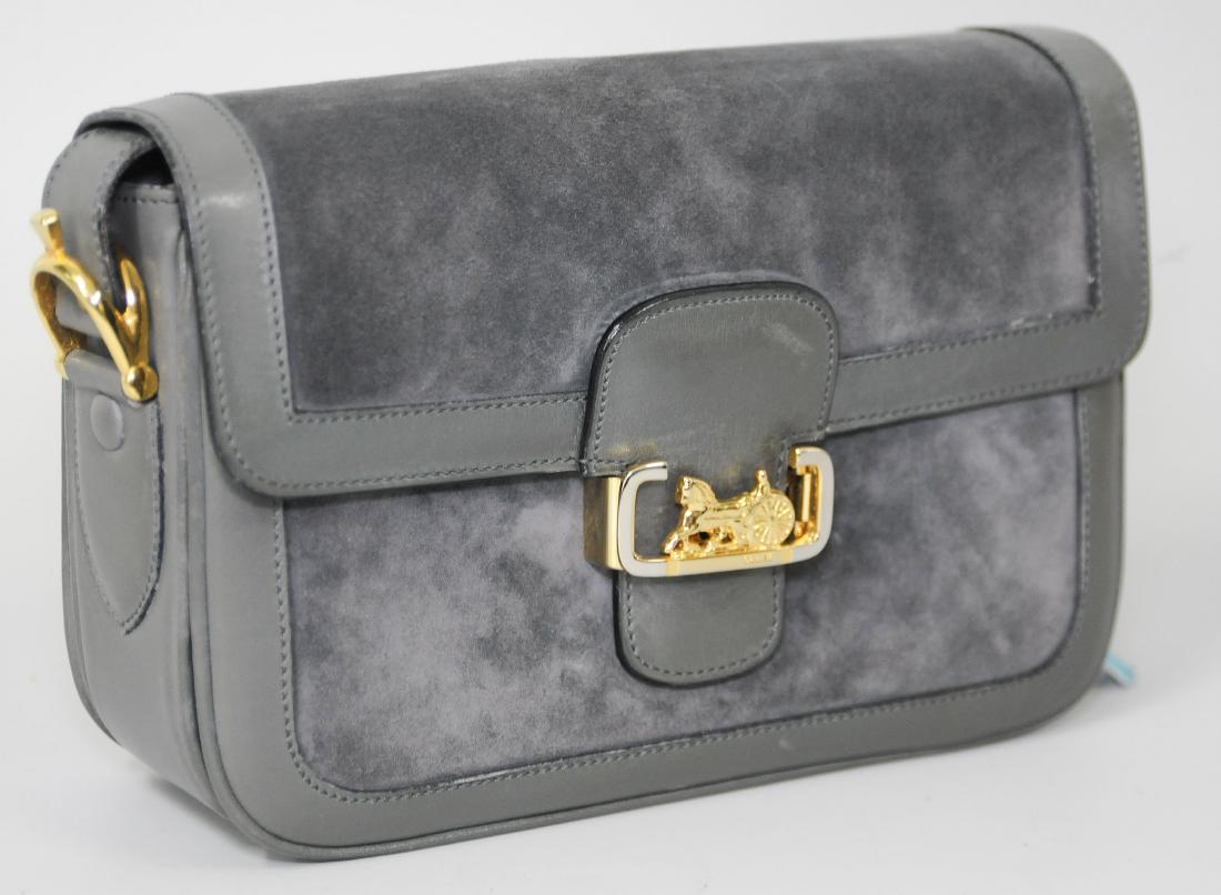 Céline, Handtasche Graues Wildleder mit Besätzen aus: Céline, Handtasche Graues Wildleder mit Besätzen aus gleichfarbigem Glattleder. Goldfarbene Metallbeschläge. Langer Schulterriemen. Steckverschluss. In Original-Schutzbeutel. 23x14x8 cm. Minimal ve