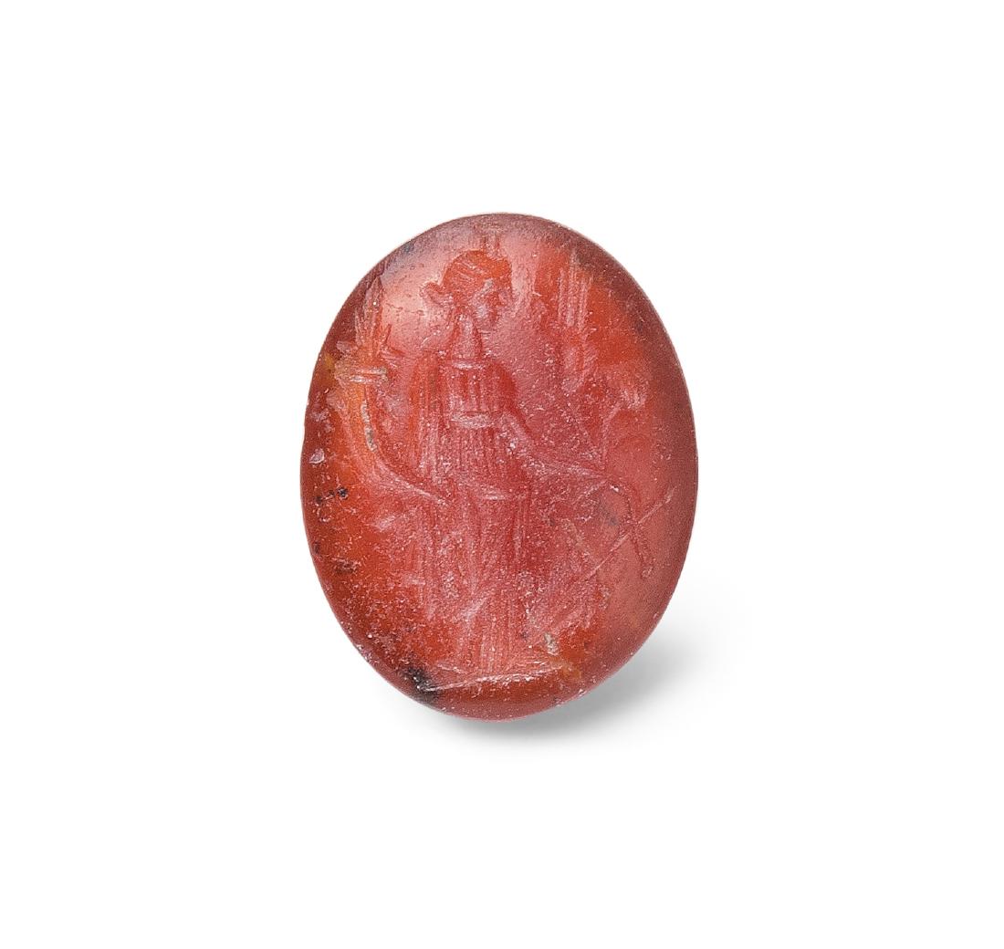 Intaglio Römisch, 1.Jh. n.C. Karneol, hochoval, leicht: Intaglio Römisch, 1.Jh. n.C. Karneol, hochoval, leicht konvex. Fortuna nach rechts mit Füllhorn und Ähren. L 1,3 cm.
