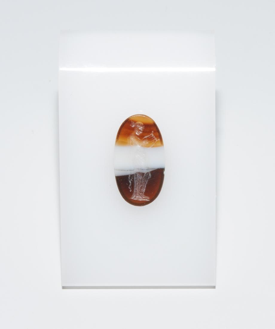 Intaglio Wohl hellenistisch, 4.Jh. v.C. Bandachat,: Intaglio Wohl hellenistisch, 4.Jh. v.C. Bandachat, hochoval, flach: Frauengestalt in langem Gewand, Lyra spielend. L 1,8 cm.