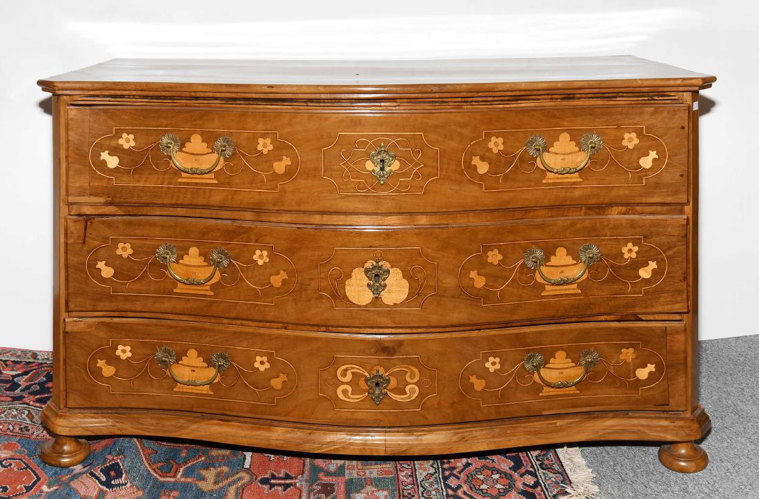 Kommode Barock ca. 1750. Nussbaum. Dreischübiger Korpus: Kommode Barock ca. 1750. Nussbaum. Dreischübiger Korpus mit gebauchter Front, auf gedrückten Kugelfüssen. Dreiseitig mit geometrischen Feldern intarsiert. Platte wohl später. Gebrauchsspuren. 130x