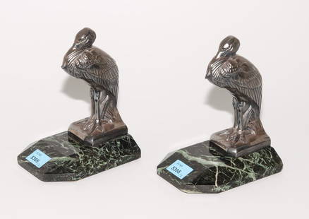 1 Paar Buchstützen Art Déco. Nach einem Entwurf von: 1 Paar Buchstützen Art Déco. Nach einem Entwurf von Maurice Frécourt. Pelikan aus versilbertem Weissmetall auf grün-schwarzem Steinsockel. - Reparaturstelle.