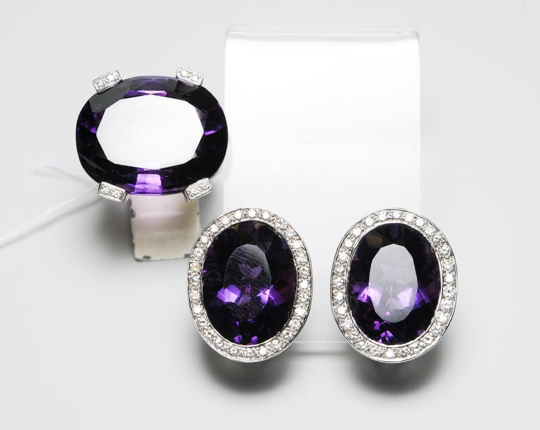 Set: Amethyst-Brillant Ring und Ohrclips Max Zubler.: Set: Amethyst-Brillant Ring und Ohrclips Max Zubler. 750 Weissgold. Ohrclips mit 2 ovalen Amethysten zus. 33.30 ct, 57 Brillanten zus. 1.14 ct. 2x1,5 cm. Ring mit 1 Amethyst-Cushion ca. 35 ct, 24 Bril