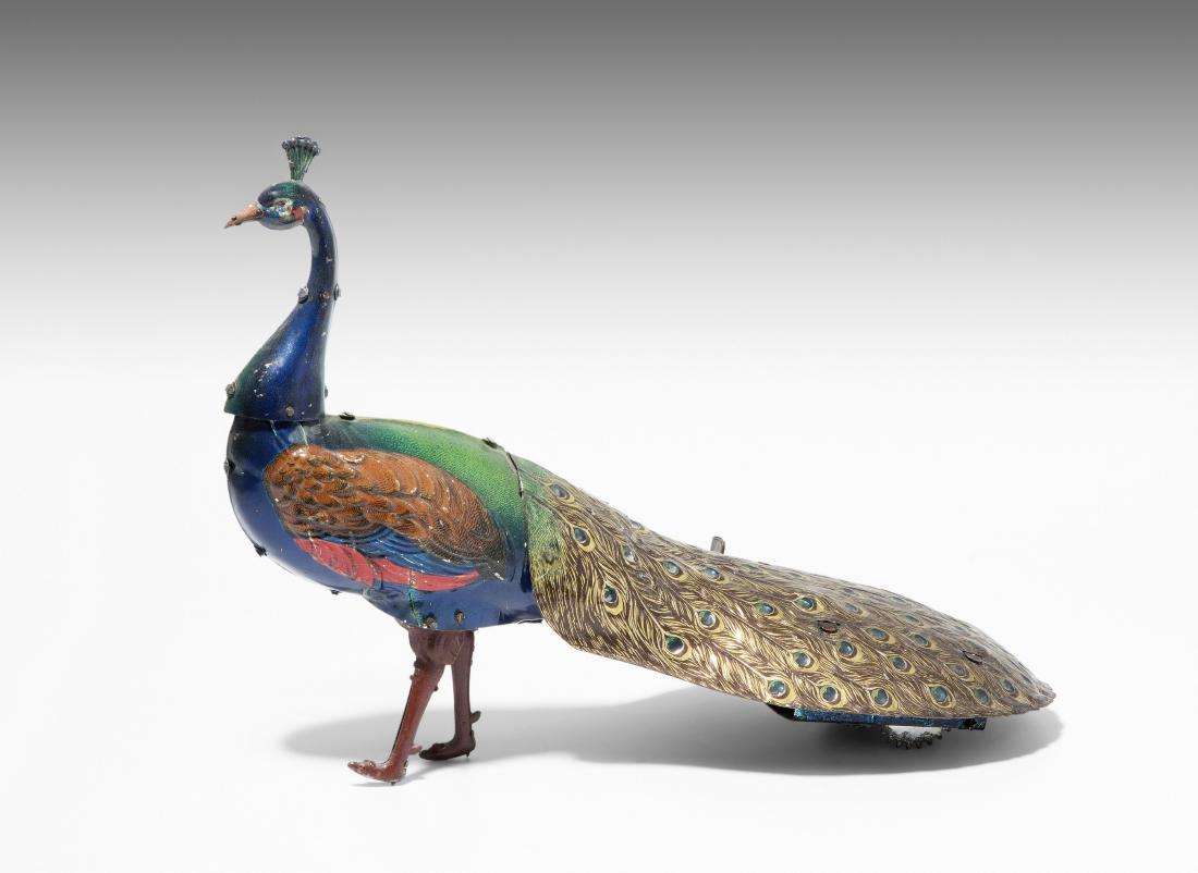 Hans Eberl (Ebo)-Tierfigur "PAO PAO" Deutschland, um: Hans Eberl (Ebo)-Tierfigur "PAO PAO" Deutschland, um 1915. Blech, farbig lithographiert. Schreitender Pfau mit ausgebreiteten Schwanzfedern. Mit Blasebalg und Uhrwerkantrieb. L 23 cm. - Leicht bespiel