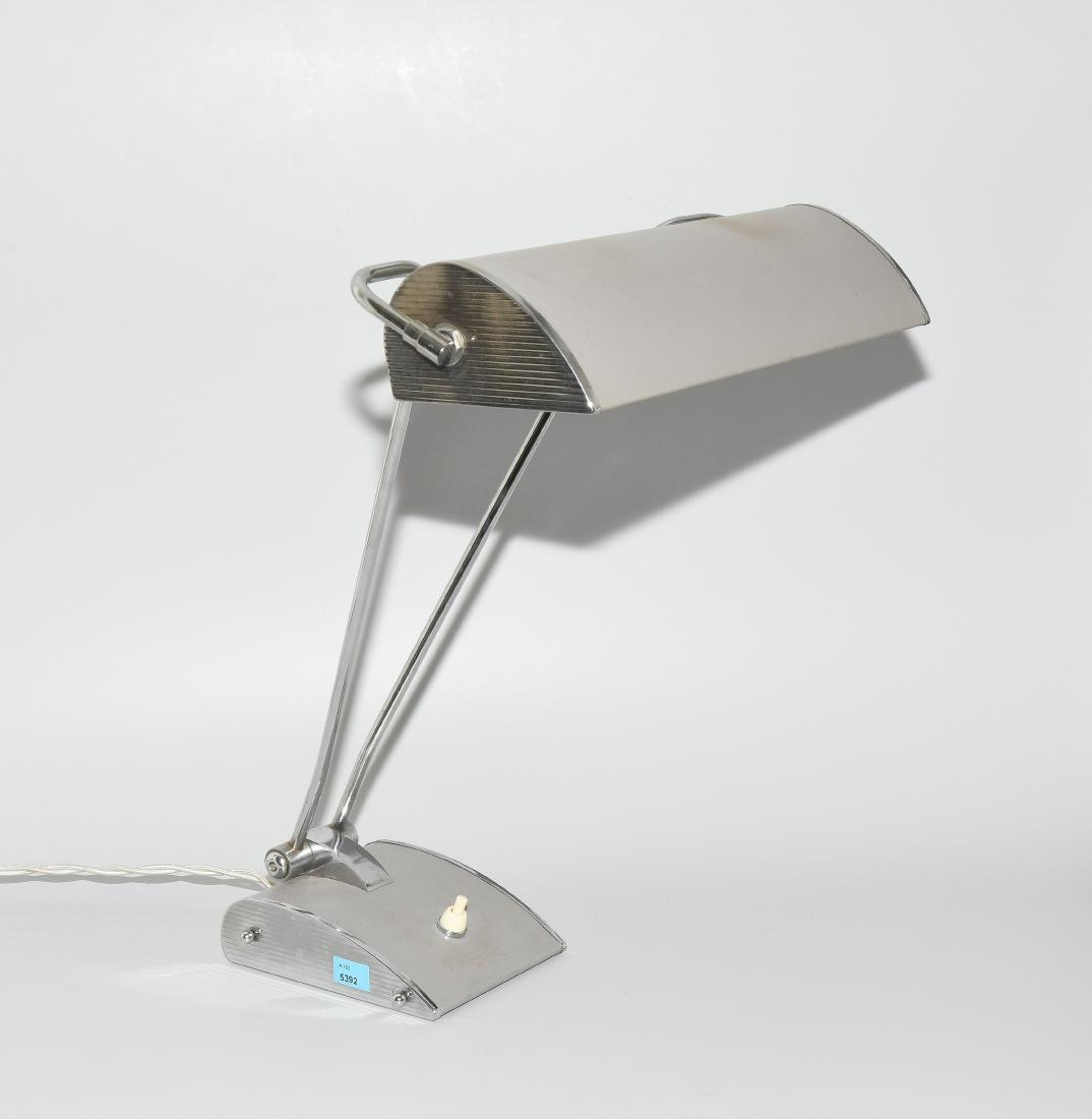 Schreibtischlampe 20.Jh., in der Art von Eileen Gray.: Schreibtischlampe 20.Jh., in der Art von Eileen Gray. Metall, verchromt. Schwenkbarer Schirm und Fuss grau beledert. Elektrifiziert. H 43 cm.