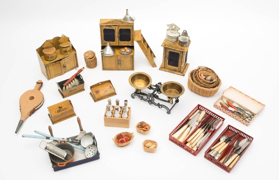 Lot Puppenküchenmöbel und -Zubehör: Deutschland, wohl Rock & Graner, um 1910. (1) Möbel aus Metall mit heller faux-grains-Bemalung. Bestand: Buffet, Anrichte, Wandschränkchen und Leiter. Div. Behälter für Müll, Holz, Mehl etc. (2) 