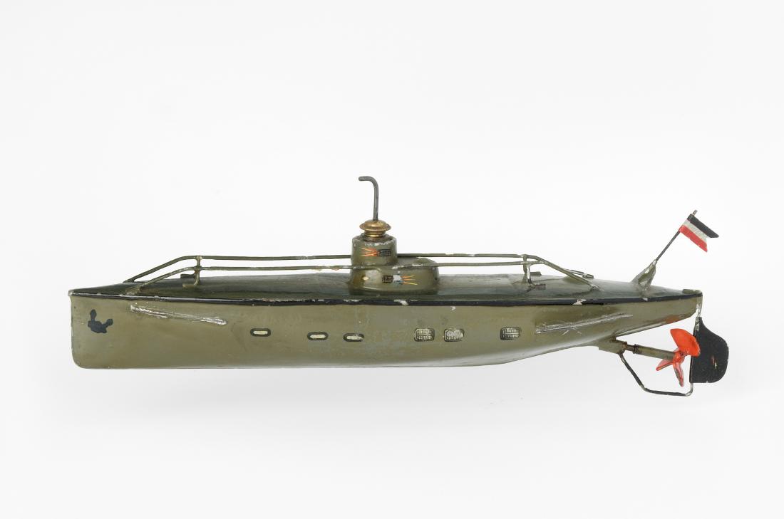 Märklin-Unterseeboot: Deutschland, 1910/20er Jahre. Blech, handlackiert. Grüner Rumpf mit Geländer, roter Schraube und französischer Flagge am Heck. Uhrwerkantrieb (zu revidieren). L 30,5 cm. - Farbabplatzer. Motor bloc