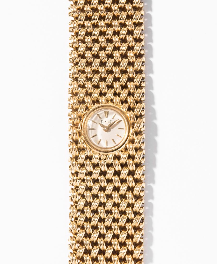 Piaget Damenarmbanduhr: 1950er Jahre. 750 Gelbgold. Piaget Handaufzug Cal. 6N. Kleines Gehäuse mit versilbertem Zifferblatt und applizierten Indizes mit Plexiglas, integriert in ein massives Ährenband. L 19 cm, 97,3 g. Fun
