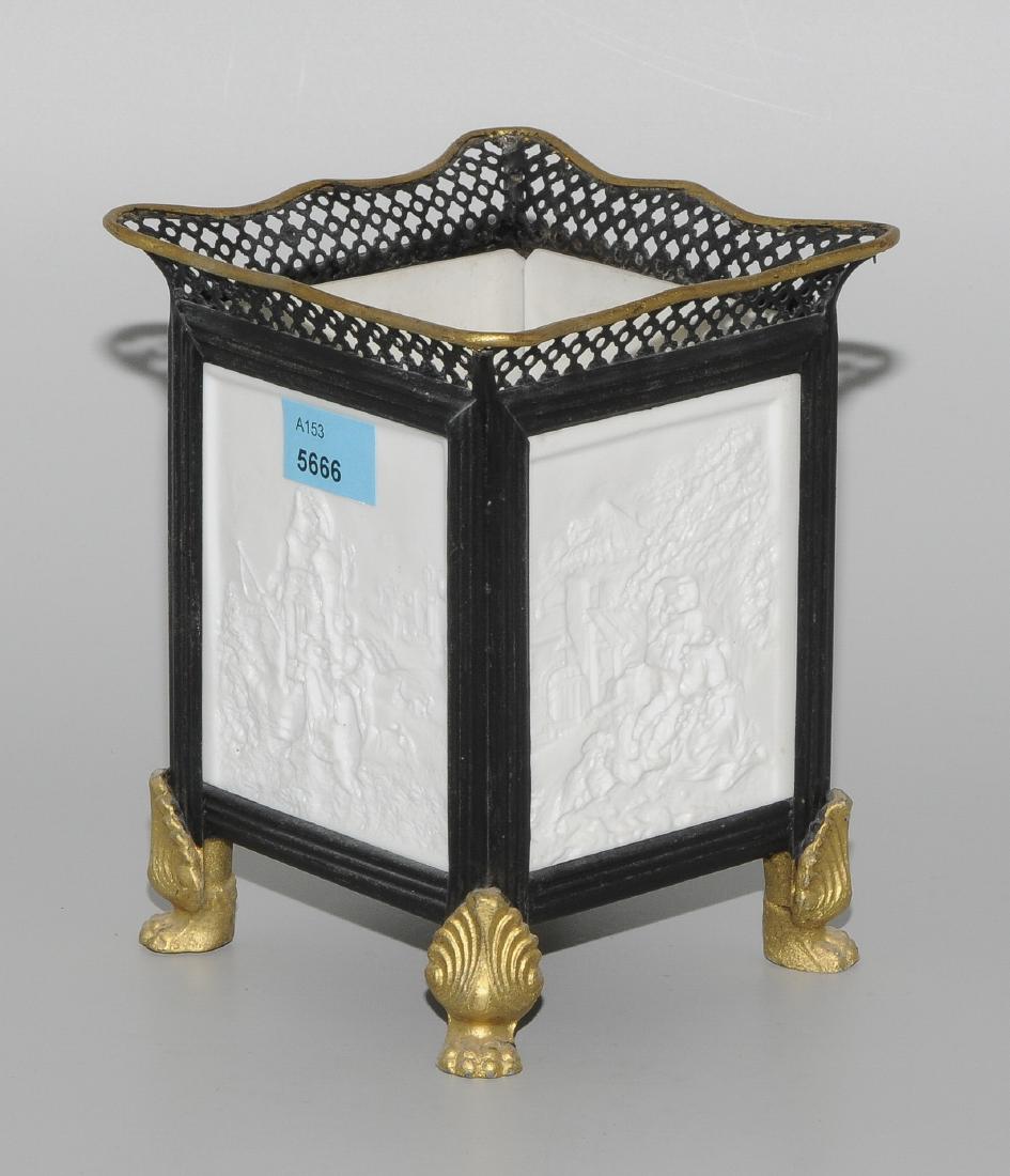 Lithophanie Lampe: Um 1900. Biskuitporzellan. 4 Platten mit Darstellung von diversen Genreszenen im Relief. Rechteckform. Metallfassung auf Tatzenfüssen, schwarz- und bronzefarben staffiert. Bezeichnet: PPM. H 14 cm.