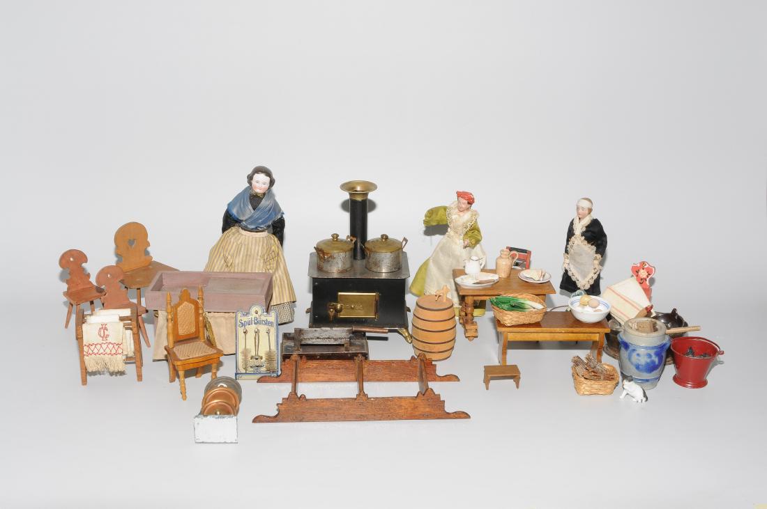 Lot: Puppenküchenmöbel und Zubehör: 19./20.Jh. Metall/Holz/Stoff/Porzellan. Diverse Möbel und Einrichtungsgegenstände in verschiedenen Ausführungen. U.a. Puppenkochherd, Puppengeschirr, Lebensmittelminiaturen und 3 Stubenpuppen. H 1�