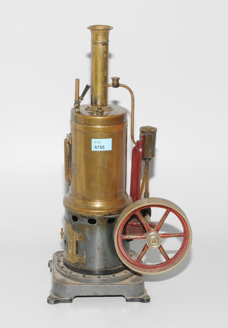 Bing-Dampfmaschine: Deutschland, um 1910. Mit Firmensignet. Stehende Dampfmaschine mit Messingkessel. Sockel aus Gusseisen. Mit Feuerungstürchen und Brenner. Schwungrad mit Durchmesser von 10 cm. H 34 cm. - Bespielt. Le