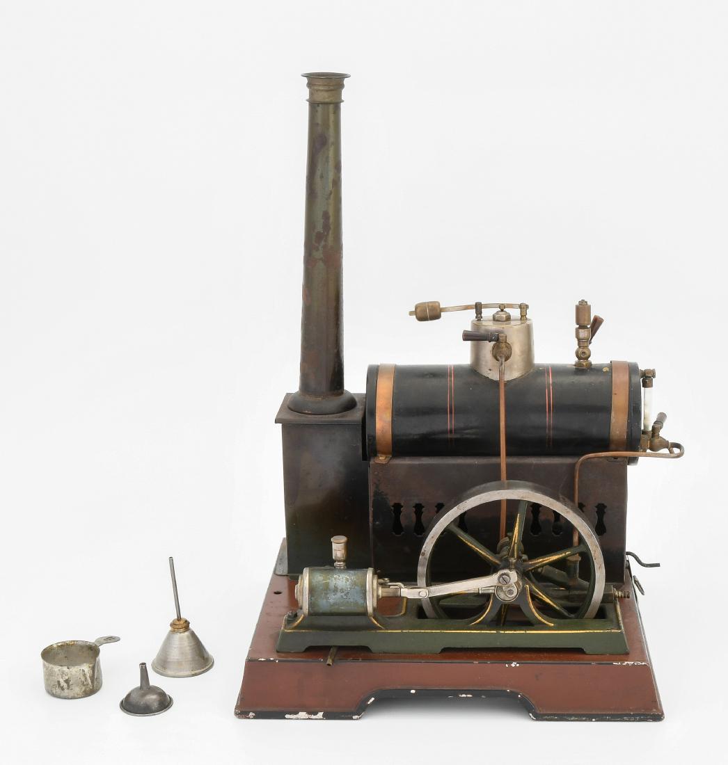 (Märklin-)Dampfmaschine: Deutschland, um 1920. Ohne Firmensignet. Liegende Dampfmaschine auf rechteckigem Fundament mit Schnurlaufrille. Schwarz lithographierter Kessel. Mit Kamin und Brenner. Schwungrad mit Durchmesser von 1