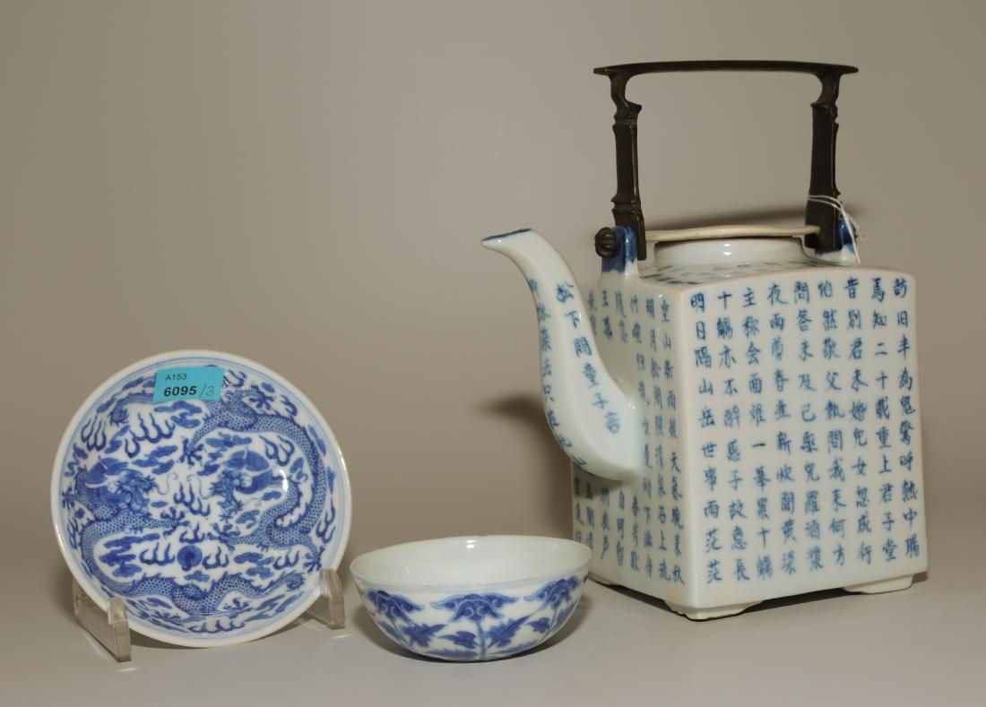 Lot: 1 Teekanne und 2 kleine Schalen: China, 20.Jh. Blau-Weiss-Porzellan. Quadratische Teekanne allseitig verziert mit dem Gedicht "Herbstabend in den Bergen" von Wang Wei. Henkel aus Metall. Boden mit Ren Shen Zhencang-Marke. H 13. / Zwe
