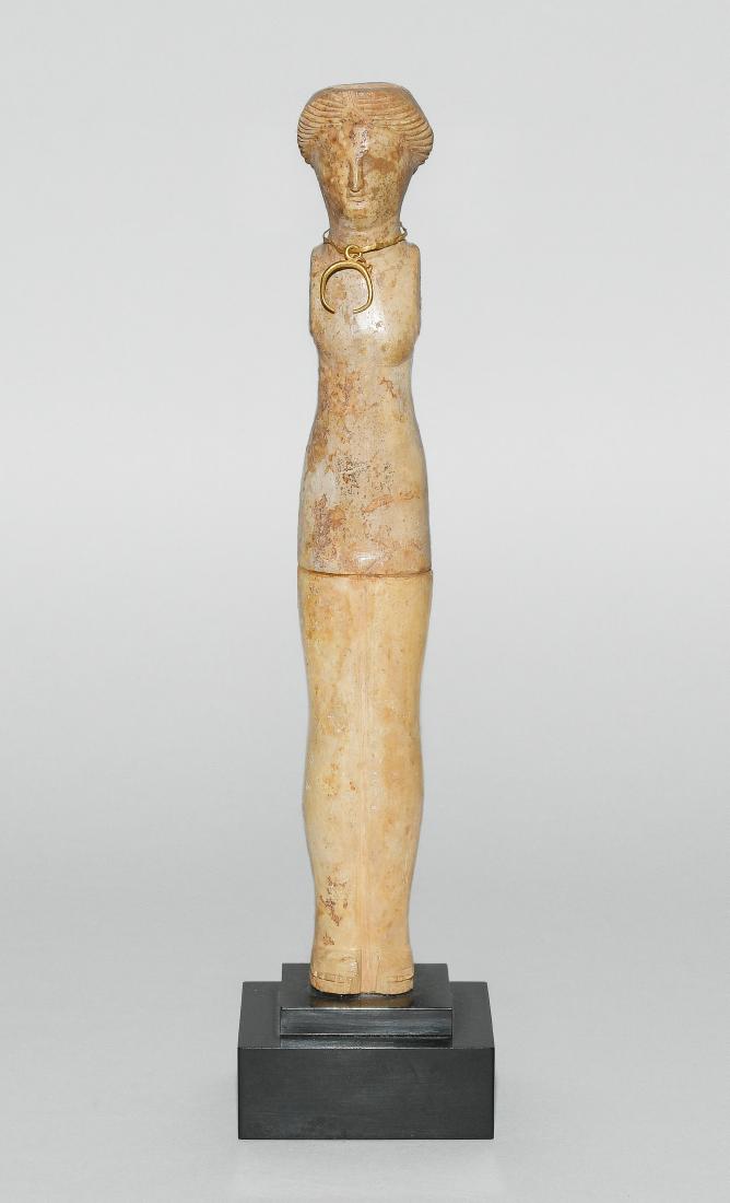 Knochenpuppe: Römisch, 2.–3.Jh. n. Chr. Knochen. Stehende Figur, vermutlich Venus darstellend. Die Haare mittig gescheitelt, der Hals verziert mit Goldschmuck. An beiden Schultern je zwei runde Löcher zur Fixie