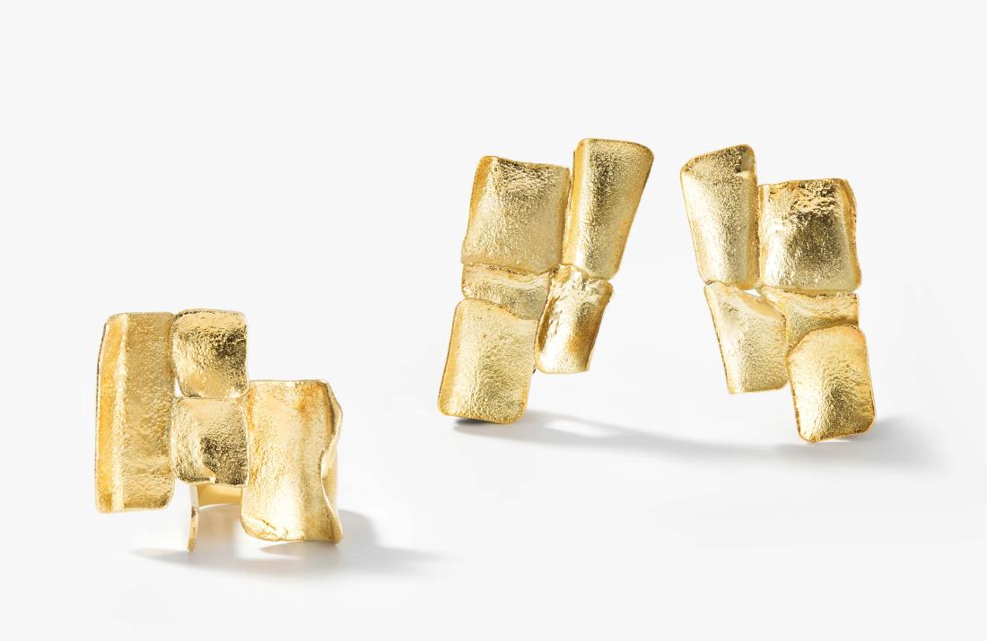 Design Gold-Set: Peter Säuberli, Olten. 1986-90. 750 Gelbgold. Meistermarke. Zweiteilig. Ring/Ohrclips. Organisch mit geschmolzener Oberfläche. Ringgr. 53. Ohrclips 4x2 cm. Gesamtgewicht 26,7 g. 2 Originalboxen.
