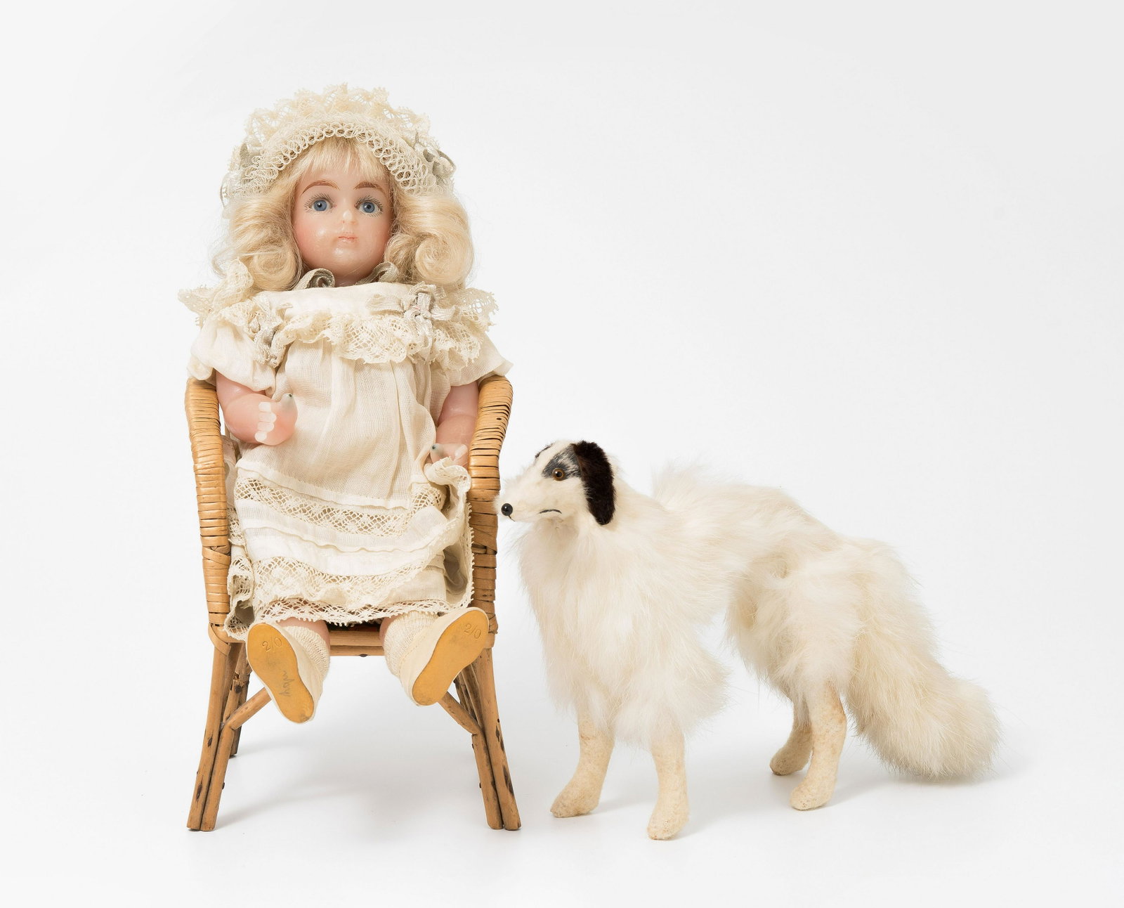 (J.D. Kestner jr.-)Wachspuppe: Deutschland, um 1900/10. Unbezeichnet. Ganz aus Wachs. Kopf mit Schlafaugen und geschlossenem Mund. Gelenkkörper mit modellierten Gliedern. Blonde Mohairperücke ergänzt. Bekleidung mit Spitzenbesat
